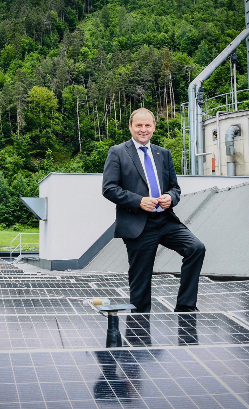 LHStv Josef Geisler steht zwischen Photovoltaik-Anlagen