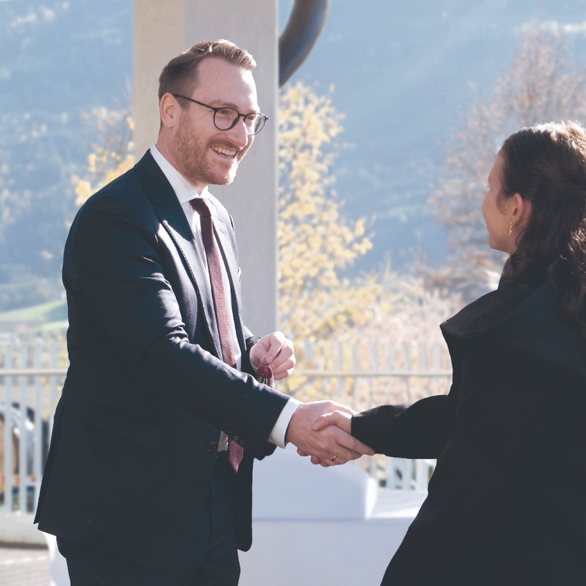 Philip Wohlgemuth überreicht einer jungen Frau den Schlüssel zu ihrer neuen Wohnung.