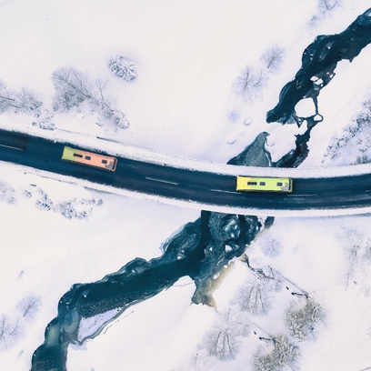 Ansicht von oben von Bussen, die auf einer Straße unterwegs sind.